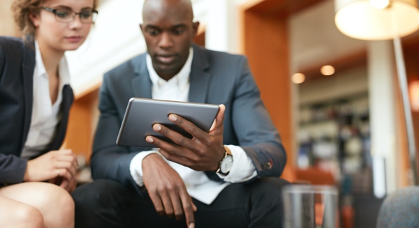 Businesspeople sitting together using digital tablet